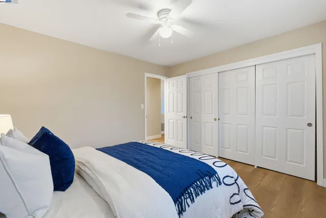 a bedroom with a bed and a chandelier fan
