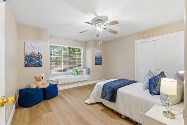 a spacious bedroom with a bed and wooden floor