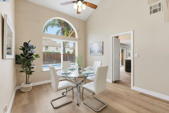 a dining room with furniture potted plants and wooden floor