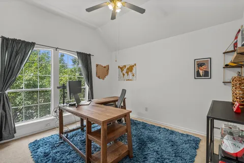 a view of a workspace with furniture and a window