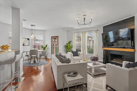 a living room with furniture a flat screen tv and a fireplace