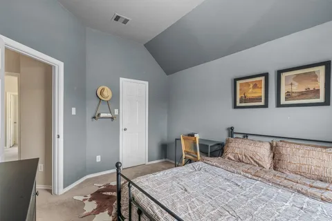 a bedroom with a bed and painting on the wall