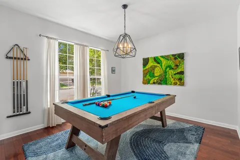 a room with pool table and windows