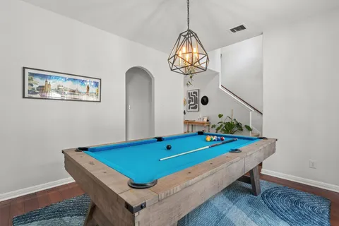 a room with pool table and chandelier