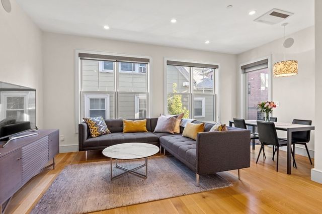 a living room with furniture a flat screen tv and a large window