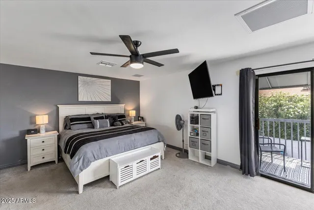 a bedroom with a bed and a flat tv screen on the dresser