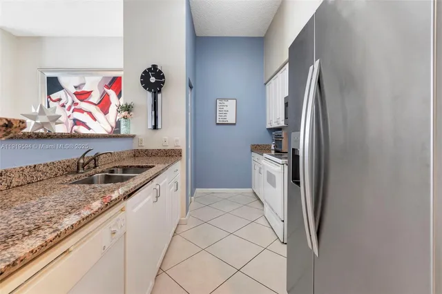 a kitchen with stainless steel appliances granite countertop a refrigerator and a stove