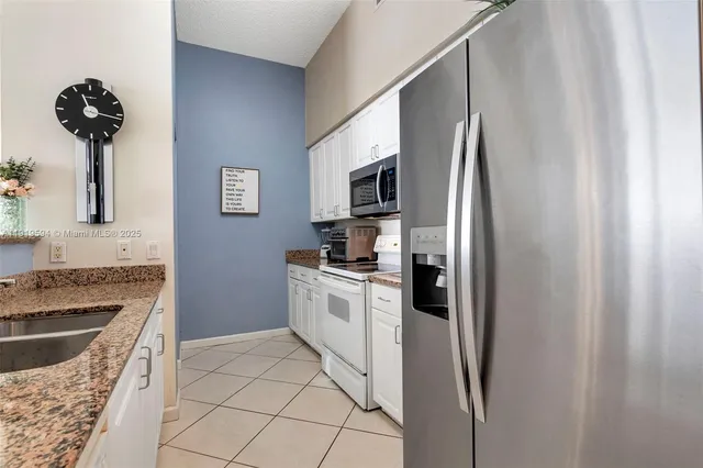 a kitchen with stainless steel appliances granite countertop a refrigerator sink and stove
