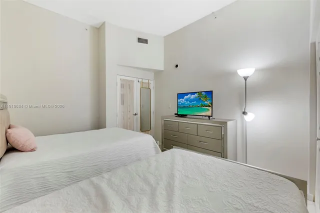 a bedroom with a bed and a flat screen tv