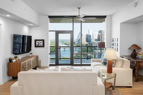 a bedroom with furniture a flat screen tv and a large window