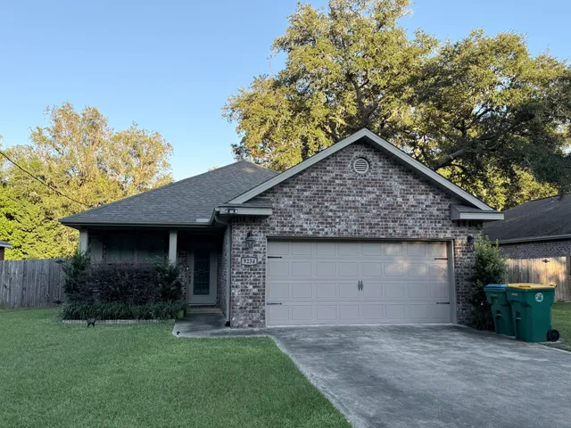 a front view of a house with a garden and yard