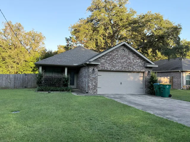 a front view of a house with a garden and yard