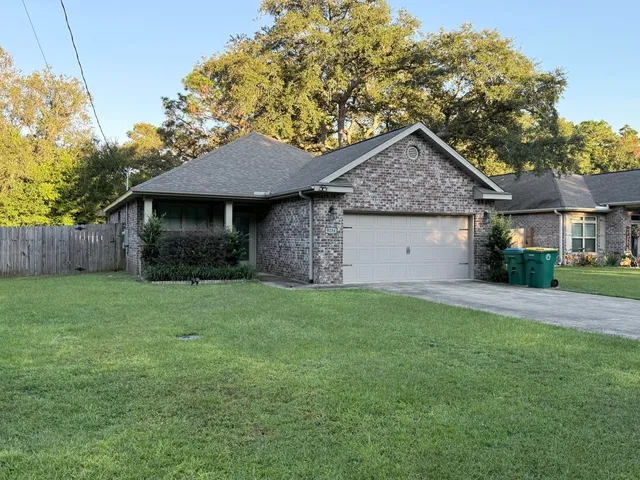 a front view of a house with a garden and yard