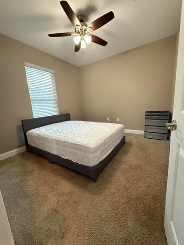 a bedroom with a bed and a ceiling fan