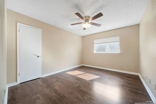 a view of a big room with wooden floor and windows