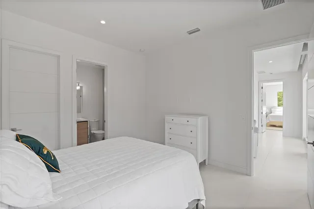 a bedroom with a bed mirror and window