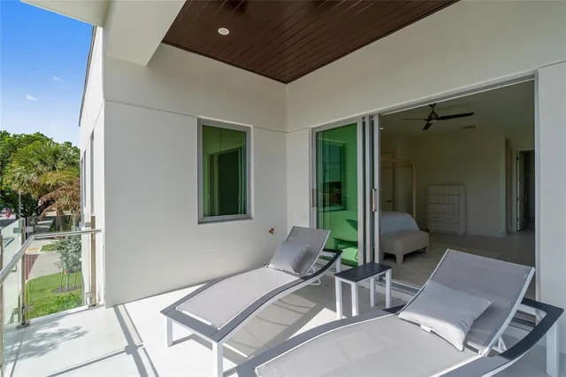 a view of a swimming pool with lawn chairs and a big yard