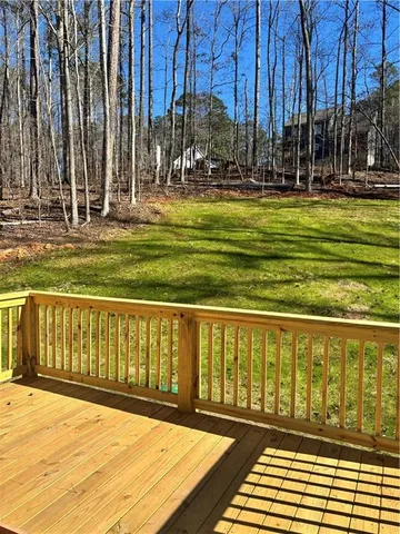 a view of a swimming pool with a lawn chairs and wooden fence