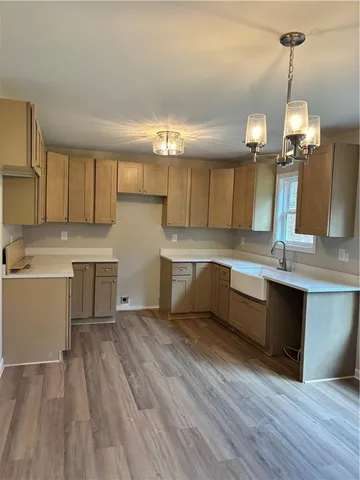 a large kitchen with cabinets wooden floor and stainless steel appliances
