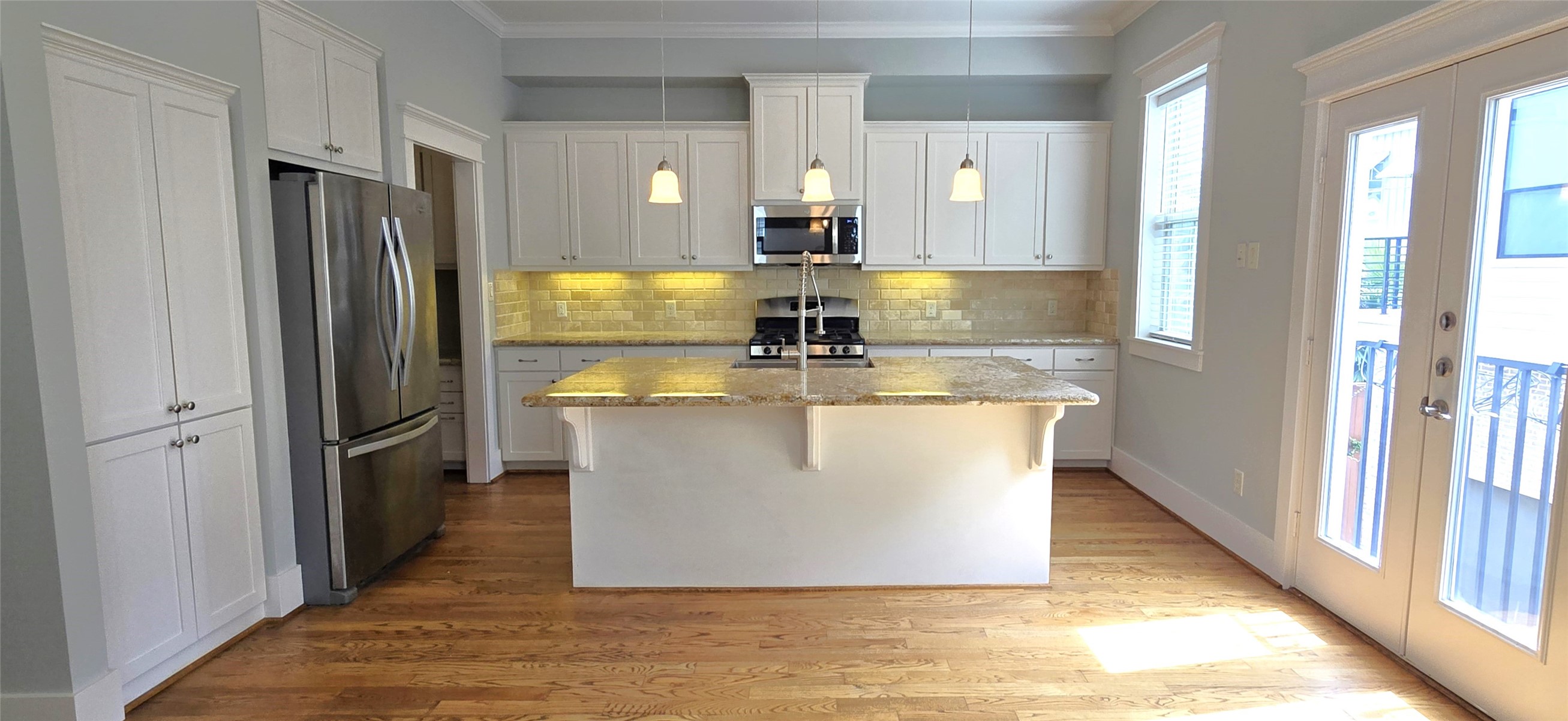 1117 Bonner Street Houston, TX 77007 - Photo 20 of 44 View from dining area into kitchen. Juliet balcony with double doors to the right. The kitchen island also features a breakfast bar.