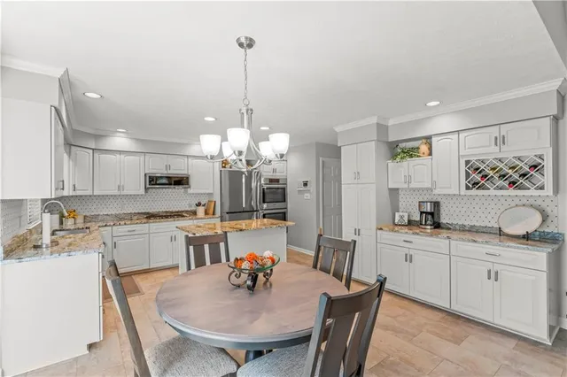 a kitchen with kitchen island granite countertop a sink a center island and cabinets