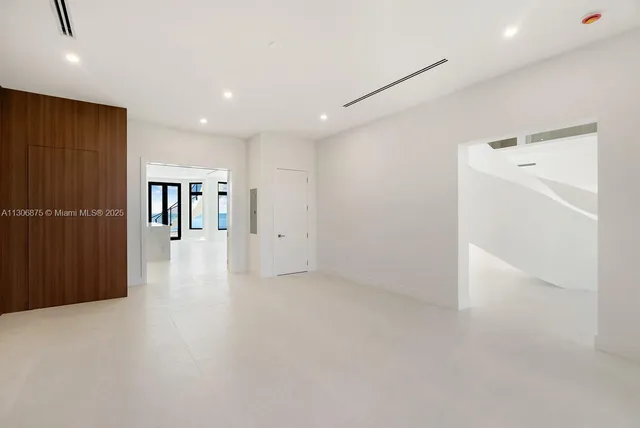 an empty room with wooden floor and windows with view