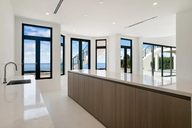 an empty room with wooden floor and windows with balcony view