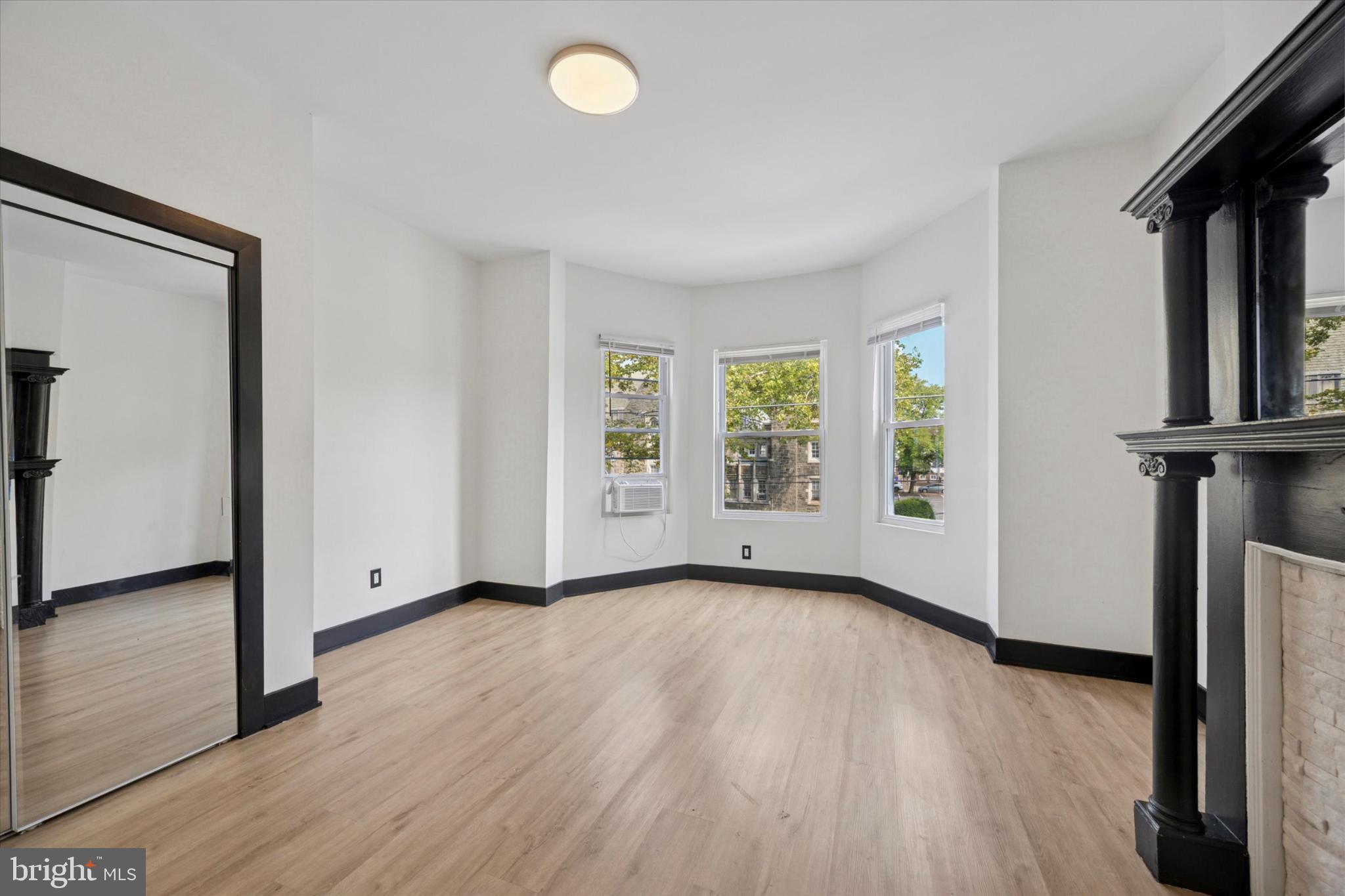 5310 Spruce Street, Unit 2 Philadelphia, PA 19139 - Photo 1 of 19 an empty room with wooden floor and windows