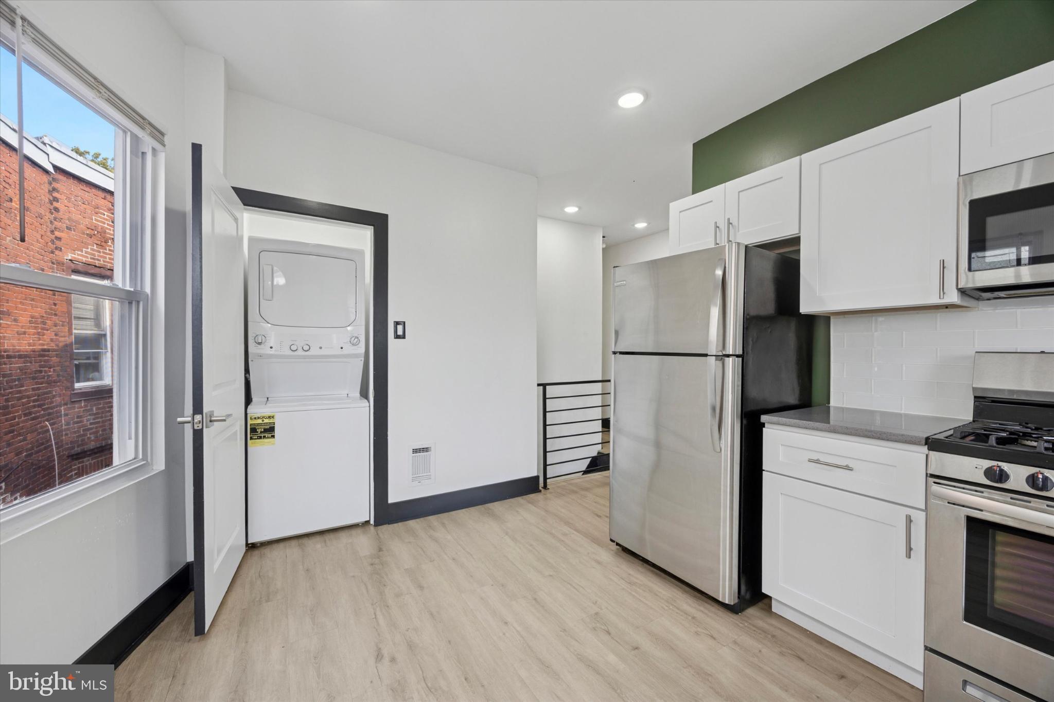 5310 Spruce Street, Unit 2 Philadelphia, PA 19139 - Photo 5 of 19 a kitchen with stainless steel appliances a refrigerator and a stove top oven