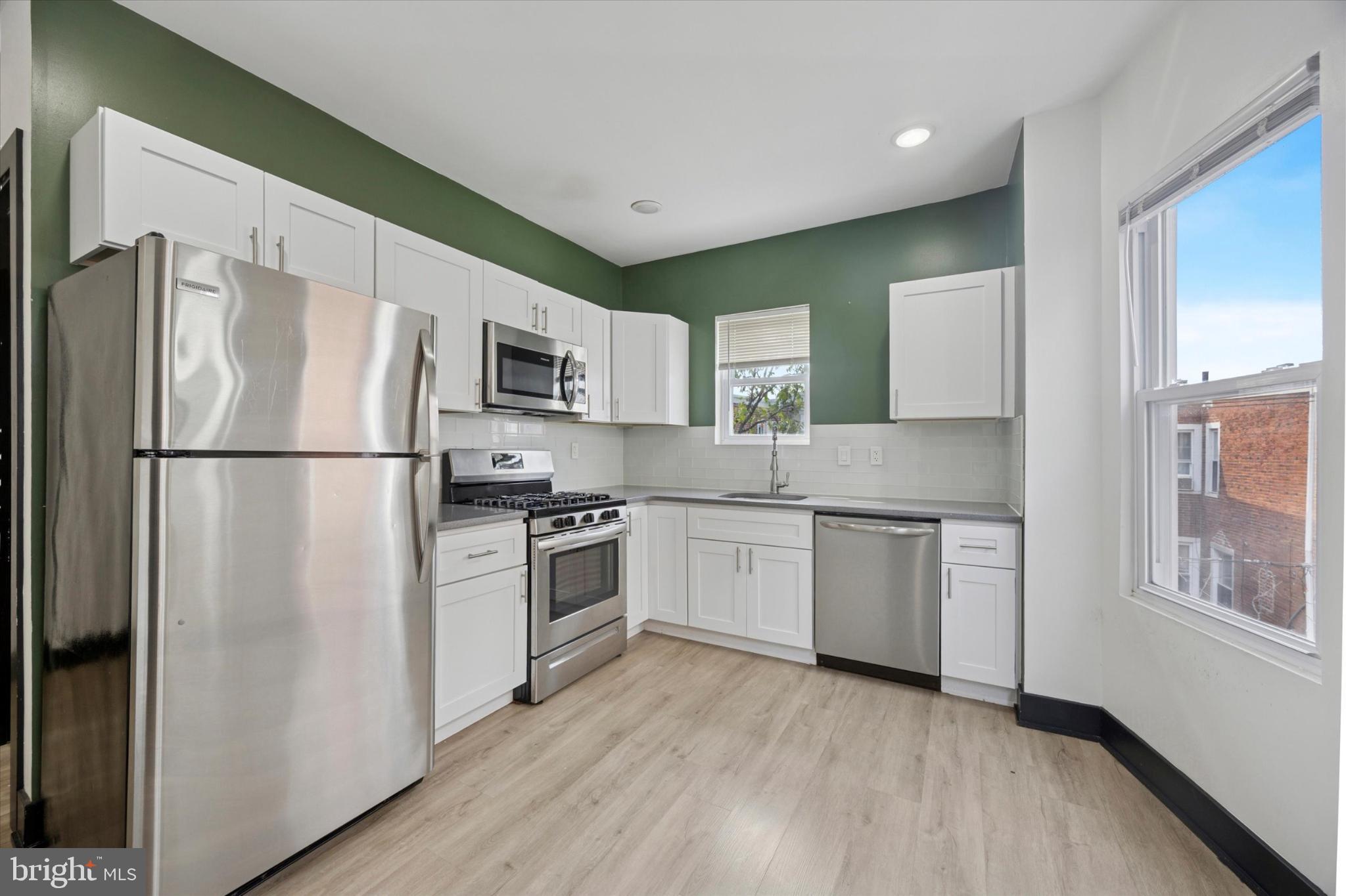 5310 Spruce Street, Unit 2 Philadelphia, PA 19139 - Photo 6 of 19 a kitchen with granite countertop stainless steel appliances a refrigerator stove top oven and sink