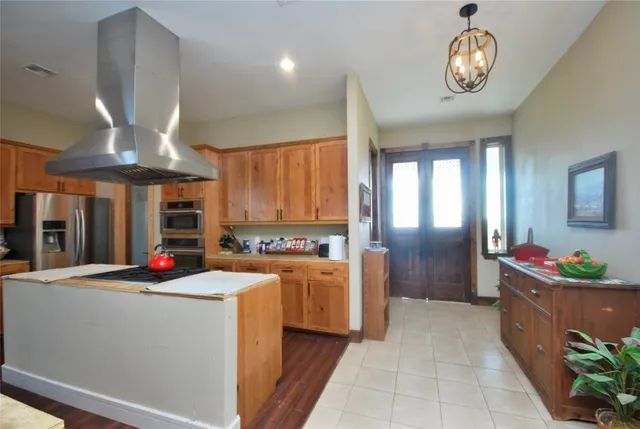 a dining room with stainless steel appliances granite countertop furniture a fireplace and a chandelier