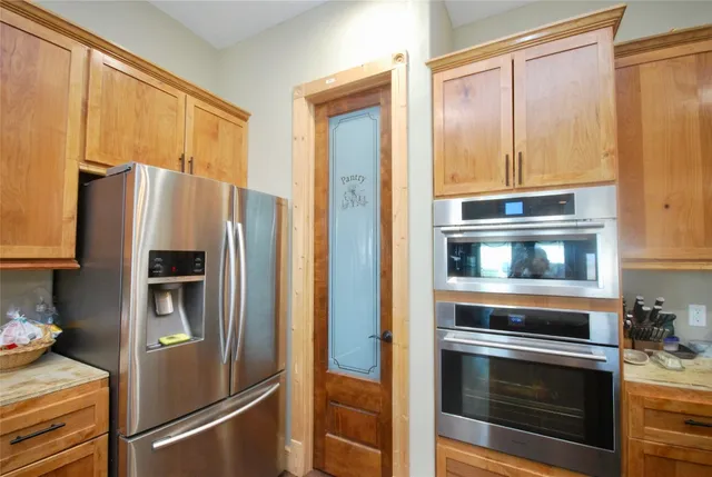 a metallic refrigerator freezer sitting in a kitchen