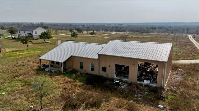 an aerial view of a house with swimming pool and furniture