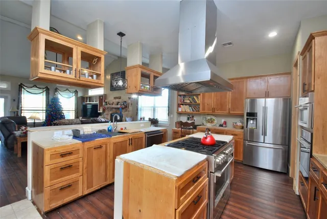 a kitchen with stainless steel appliances granite countertop a refrigerator a stove a sink and a refrigerator