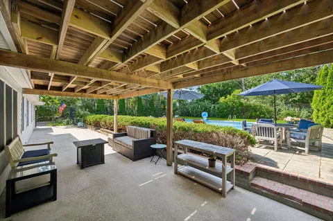 a view of a patio with couches and chairs under an umbrella