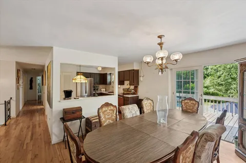 a view of a dining room with furniture a chandelier and wooden floor