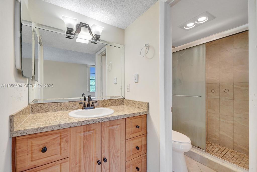 9520 Seagrape Drive, Unit 306 Davie, FL 33324 - Photo 15 of 20 a bathroom with a granite countertop sink toilet and shower