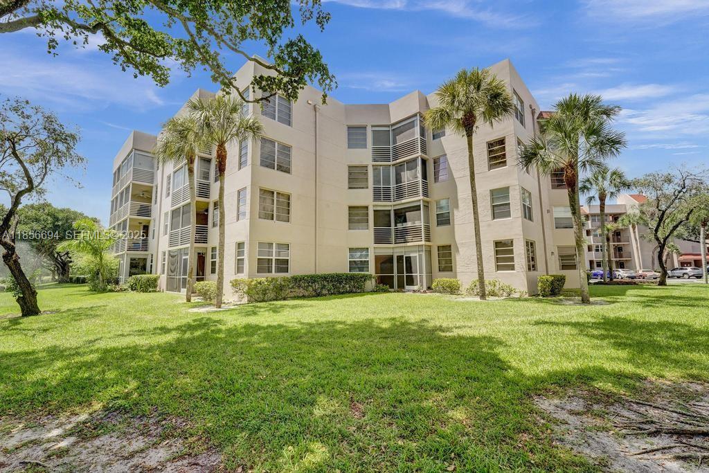9520 Seagrape Drive, Unit 306 Davie, FL 33324 - Photo 17 of 20 front view of a building with a yard