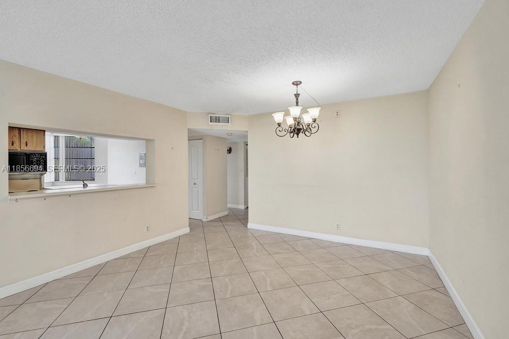 9520 Seagrape Drive, Unit 306 Davie, FL 33324 - Photo 8 of 20 a view of an empty room with chandelier