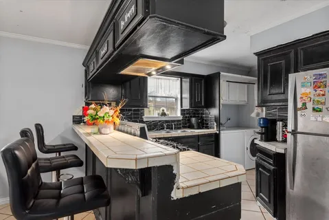 a kitchen with stainless steel appliances a table and chairs in it