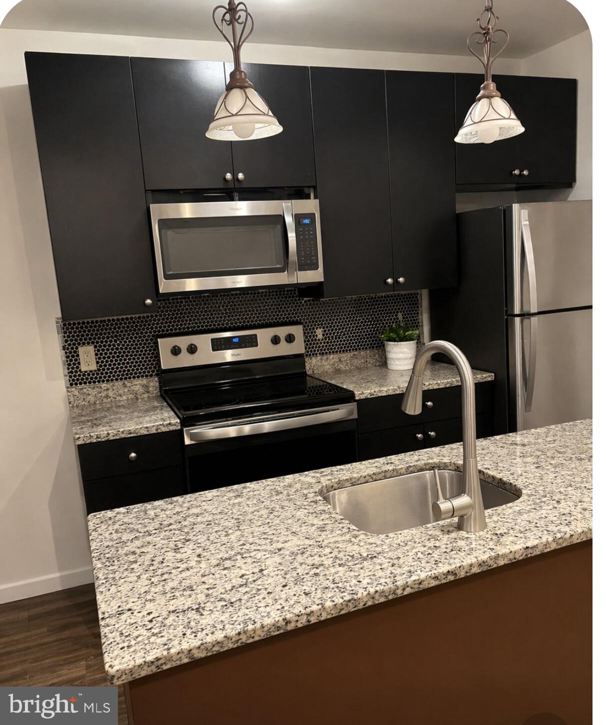 759 19th Street Northeast Washington, DC 20002 - Photo 4 of 4 a kitchen with stainless steel appliances granite countertop a sink a stove and a refrigerator