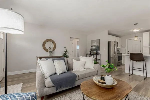 a living room with furniture and a wooden floor