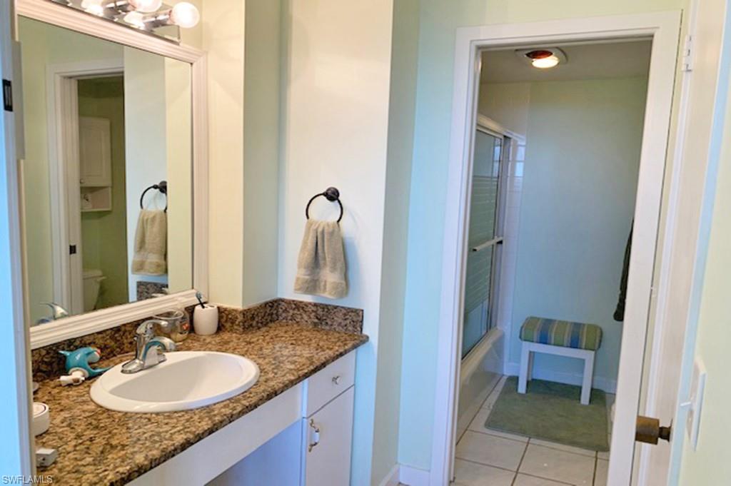 180 Seaview Court, Unit 111 Marco Island, FL 34145 - Photo 11 of 24 a bathroom with a granite countertop sink and a mirror