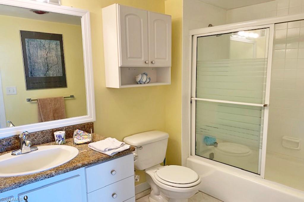 180 Seaview Court, Unit 111 Marco Island, FL 34145 - Photo 14 of 24 a bathroom with a granite countertop sink toilet and shower