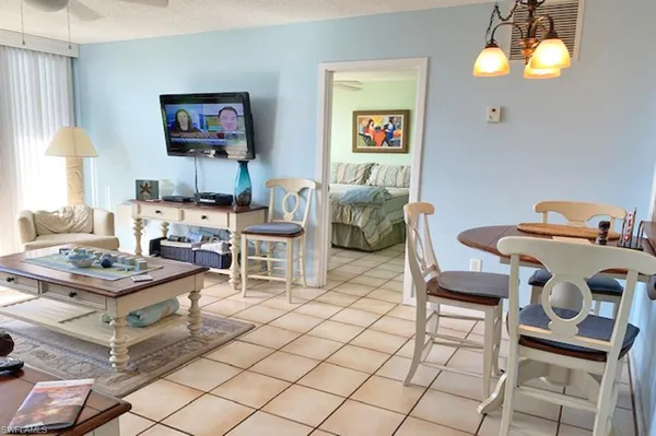 a living room with furniture a chandelier and a flat screen tv