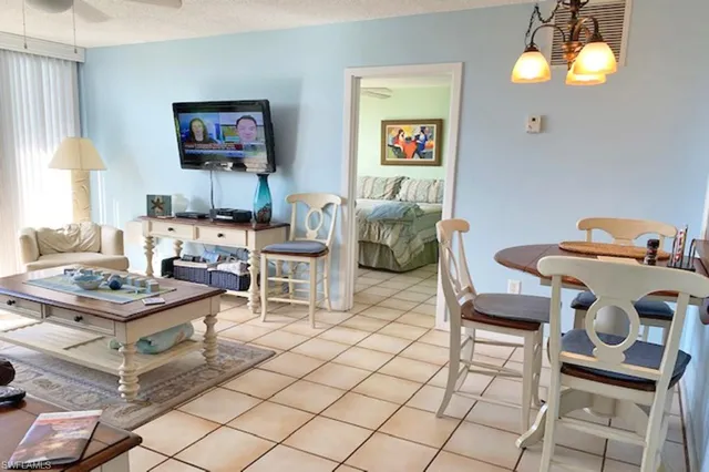 a living room with furniture a chandelier and a flat screen tv