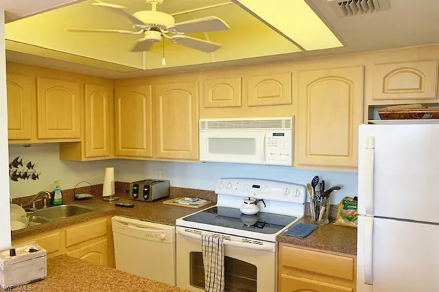 a kitchen with stainless steel appliances granite countertop a sink a stove and refrigerator