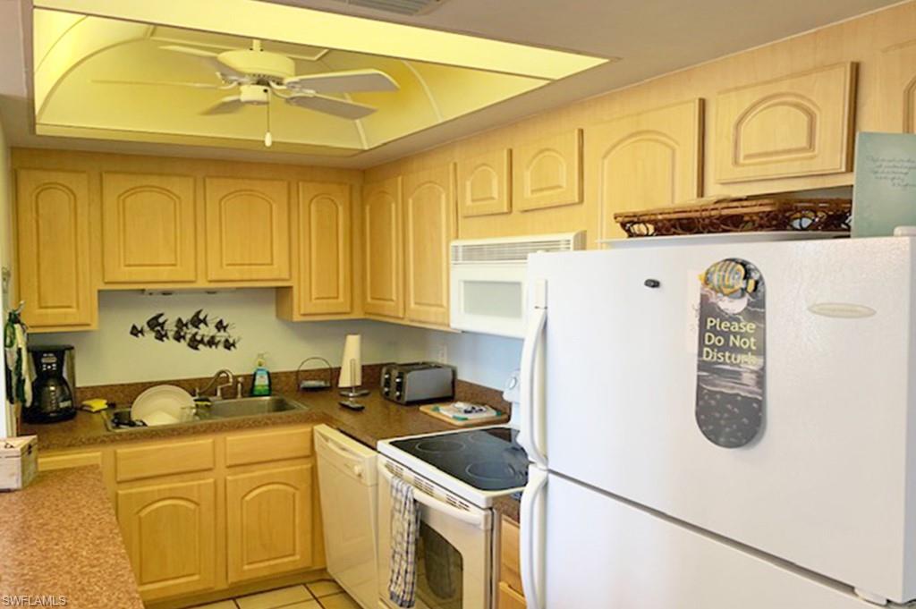 180 Seaview Court, Unit 111 Marco Island, FL 34145 - Photo 8 of 24 a kitchen with stainless steel appliances granite countertop a sink a stove a refrigerator a counter space and cabinets