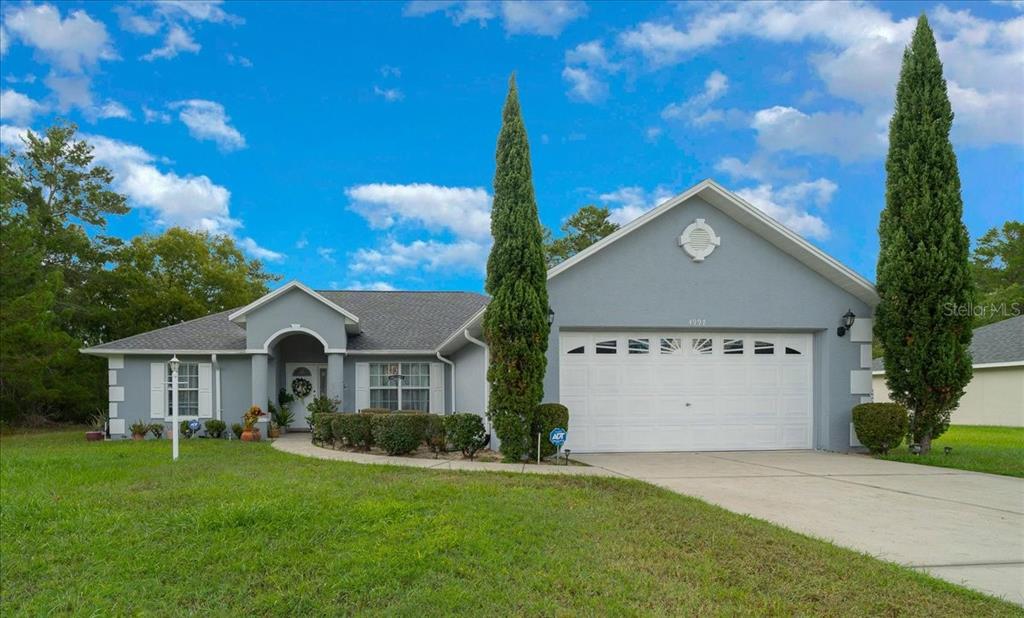 4997 Southwest 107th Loop Ocala, FL 34476 - Photo 1 of 48 a front view of a house with a garden