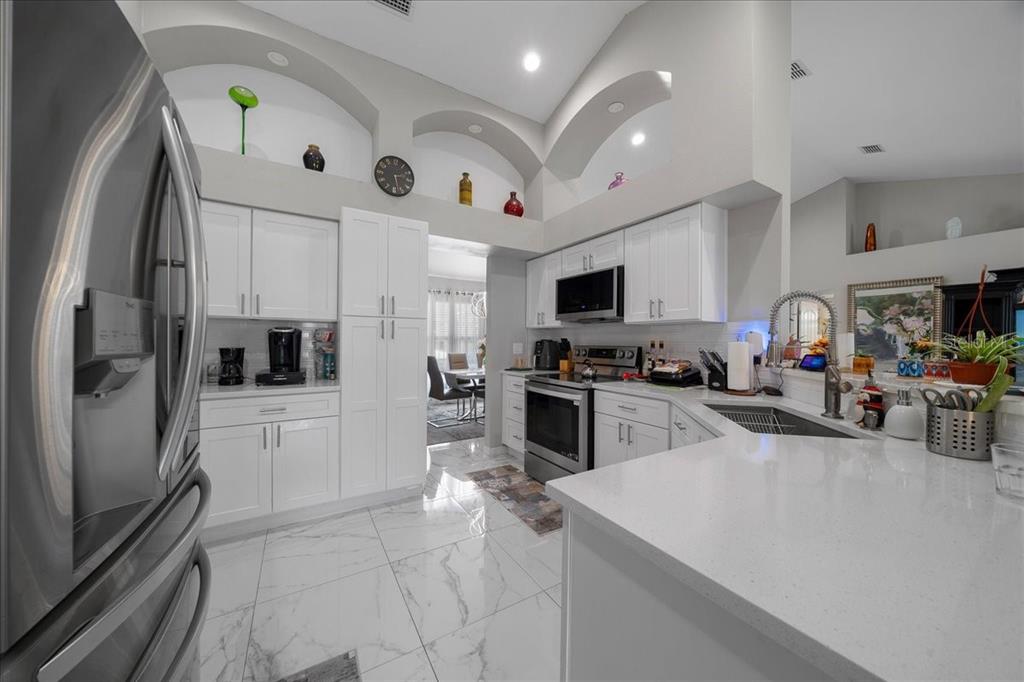 4997 Southwest 107th Loop Ocala, FL 34476 - Photo 11 of 48 a kitchen with refrigerator and cabinets